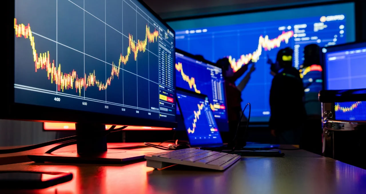 Mesa de operações com gráficos de mercado em múltiplos monitores